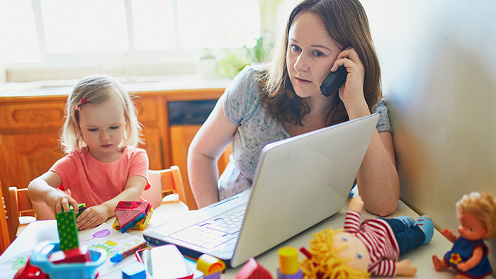 Exhausted and stressed mother working from home with toddler