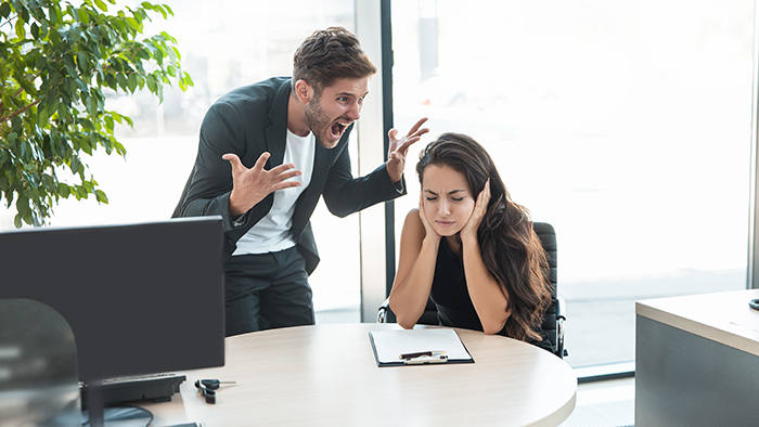 strict boss man swearing at depressed employee woman for bad work at the workplace looking angry