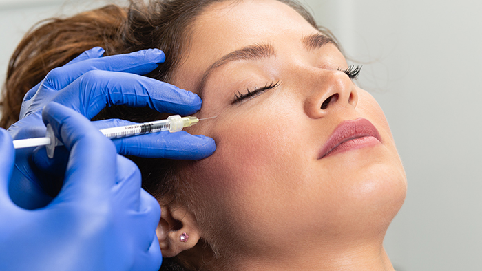 Attractive young woman is getting a rejuvenating facial injectio