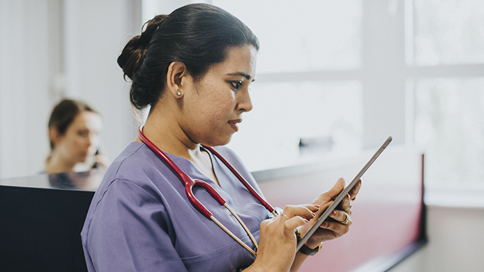 Female nurse checking the schedule on a tablet