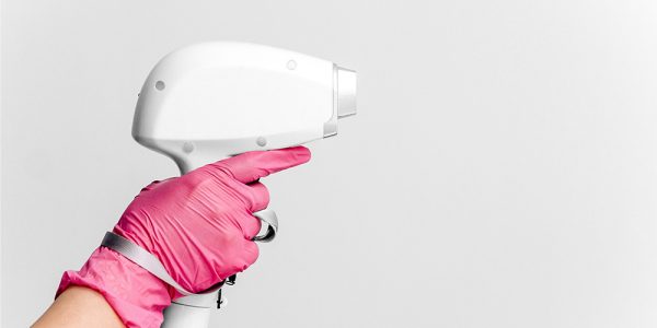gloved hand holds aesthetic laser